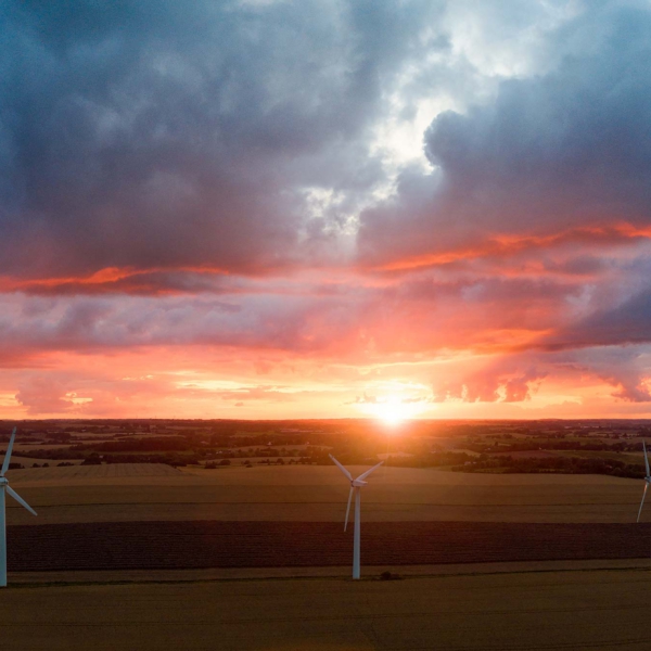 Droneoptagelse af dramatisk solnedgang over vindm&oslash;ller