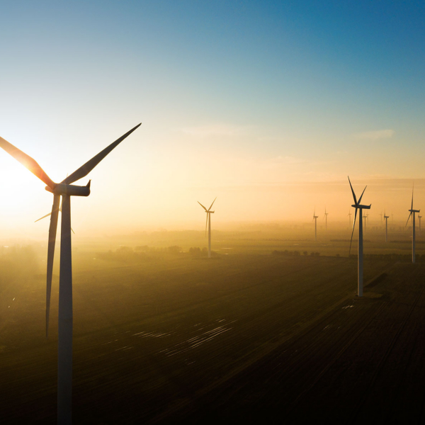 Droneoptagelse af vindm&oslash;ller i solnedgang